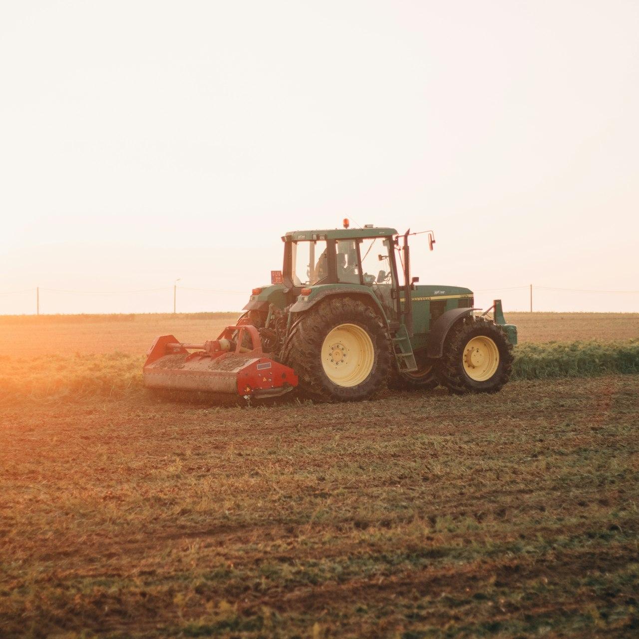 red tractor on brown field during daytime